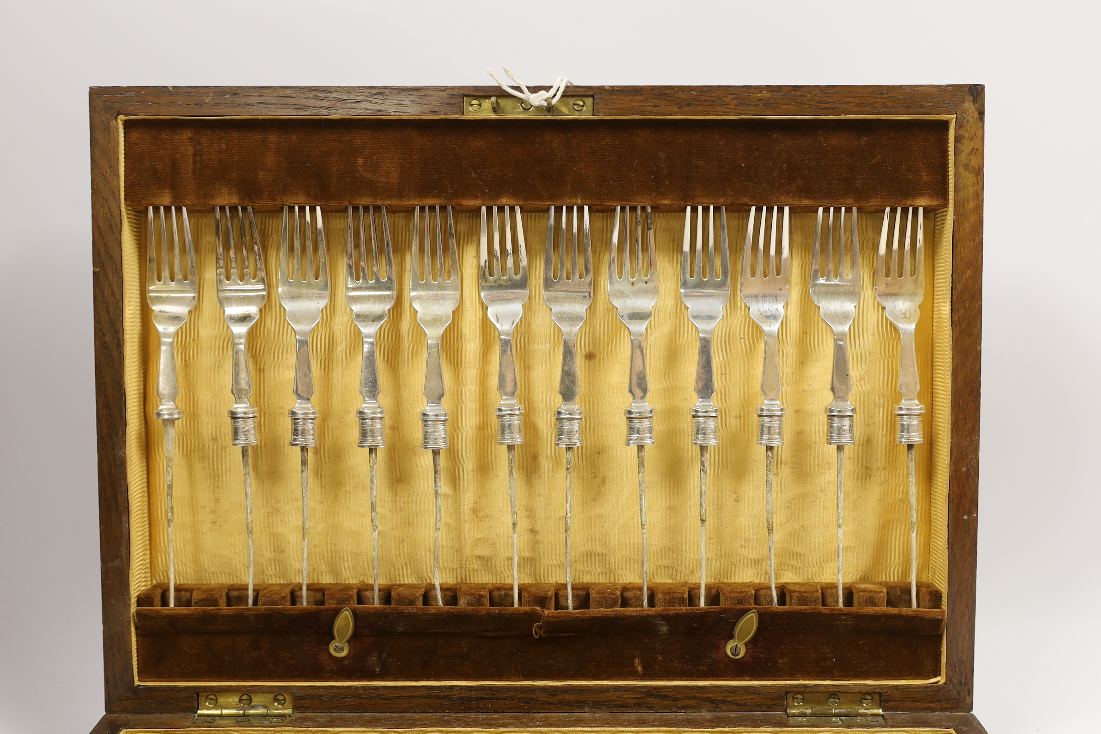 A set of twelve pairs of silver fish knife blades and fork tines, Walker & Hall, Sheffield 1933, in canteen (no handles), gross weight 24.6oz.